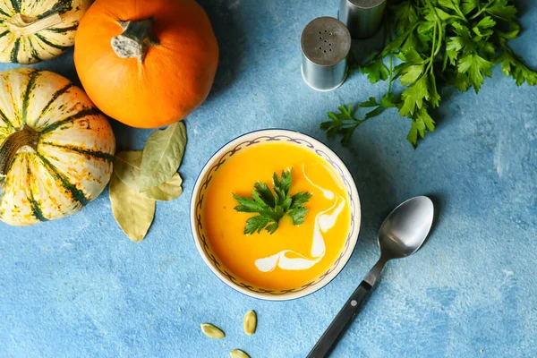 Schüssel Mit Köstlicher Kürbiscremesuppe Und Gewürzen Auf Farbigem Hintergrund — Stockfoto