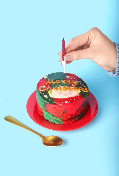 女性の手と皿にキャンドルとおいしいお弁当ケーキの色の背景 — ストック写真