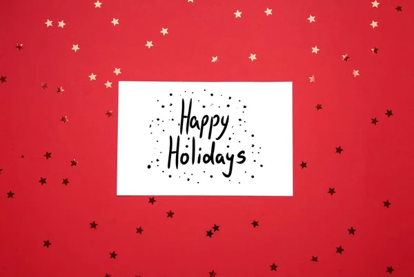 Cartão Saudação Com Texto Happy Holidays Confete Fundo Vermelho — Fotografia de Stock