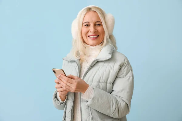 Starší Žena Zimním Oblečení Moderním Mobilním Telefonem Barevném Pozadí — Stock fotografie