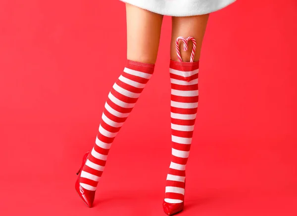 Σέξι Νεαρή Γυναίκα Χριστουγεννιάτικες Κάλτσες Και Καραμέλες Στο Φόντο Χρώμα — Φωτογραφία Αρχείου