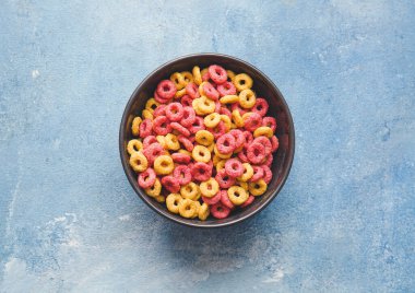 Renkli arkaplanda renkli tahıl halkaları kasesi