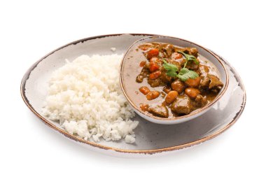 Beyaz arka planda lezzetli körili biftek ve pirinç tabağı.