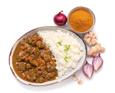 Beyaz arka planda lezzetli körili biftek ve pirinç tabağı.