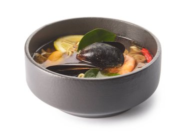 Beyaz arka planda bir kase baharatlı Tayland çorbası.