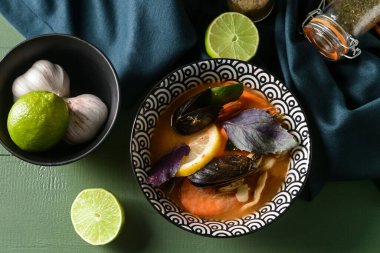 Bir kase baharatlı Tayland çorbası renkli ahşap arka planda