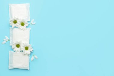 Mavi arka planda çiçekler ve adet pedleri