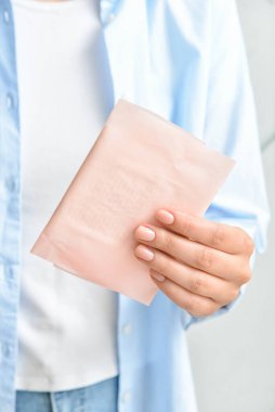 Aybaşı pedi olan kadın arka planda, yakın plan.