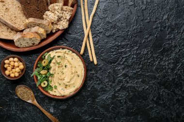 Lezzetli humus ve koyu arkaplanda ekmek ile kase