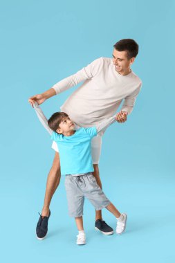 Dans eden adam ve küçük oğlu renkli arka planda