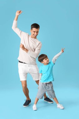 Dans eden adam ve küçük oğlu renkli arka planda