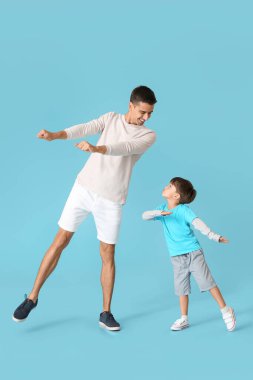 Dans eden adam ve küçük oğlu renkli arka planda