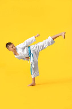 Küçük çocuk renkli arka planda karate yapıyor.
