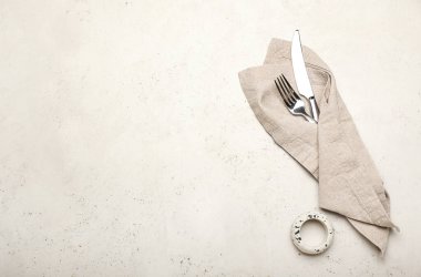 Çatal ve bıçak peçetede, arka planda.