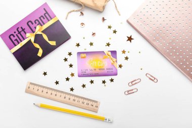 Beyaz arka planda konfeti ve kırtasiye malzemesi olan hediye kartı