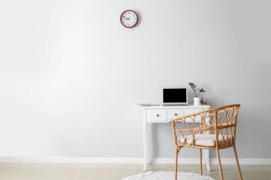Laptop ve hasır koltuklu modern işyeri