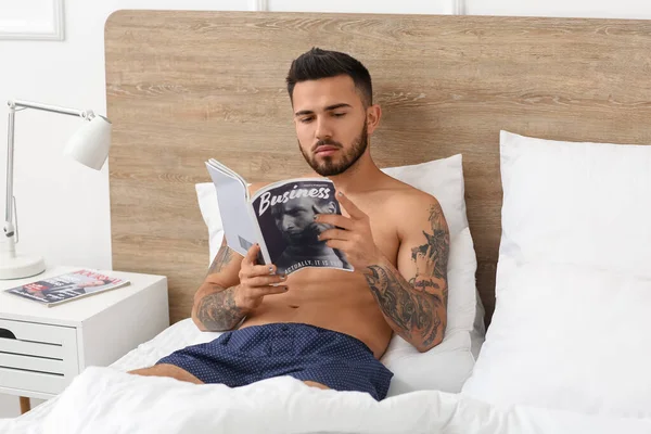 Sexy Jongeman Ondergoed Lezen Tijdschrift Terwijl Liggend Bed — Stockfoto