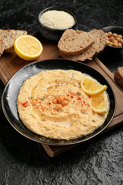 Talerz Pysznym Hummusem Chlebem Cytryną Ciemnym Tle — Zdjęcie stockowe