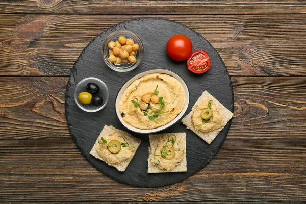 Bowl Delicious Hummus Crackers Olives Wooden Background — Stock Photo, Image