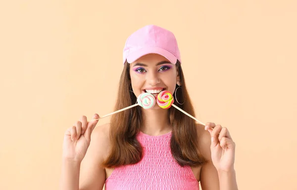 베이지 배경에 롤리팝을 분홍색 모자를 아름다운 — 스톡 사진