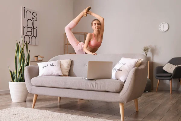 Mooie Jonge Vrouw Met Laptop Doet Gymnastiek Thuis — Stockfoto