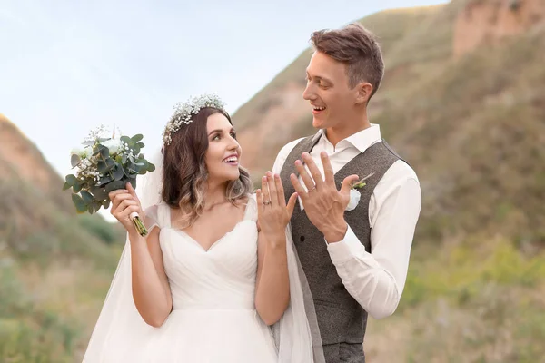 Happy Newlyweds Showing Wedding Rings Outdoors — Stock Photo, Image