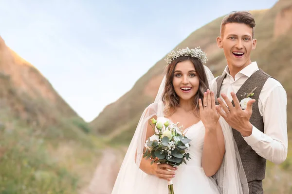 Happy Newlyweds Showing Wedding Rings Outdoors — Stock Photo, Image