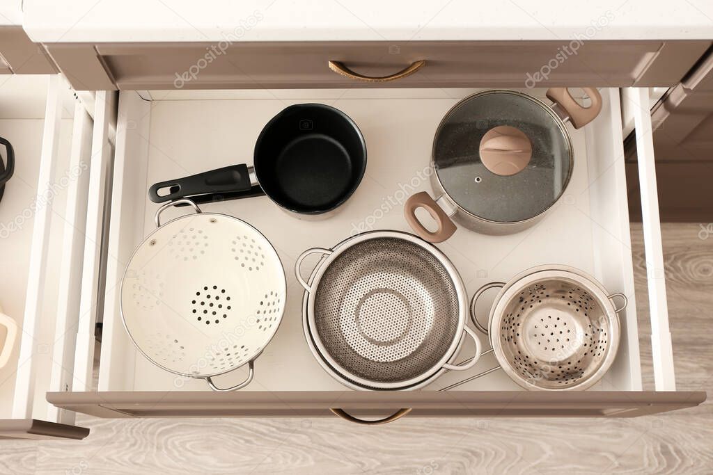 Set of kitchen utensils in open drawer, closeup
