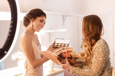 Makyaj sanatçısı güzellik salonunda güzel bir modelle çalışıyor.