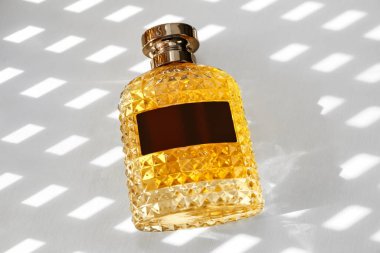 Hafif arkaplanda şık bir parfüm şişesi