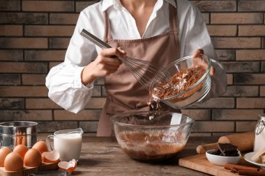 Mutfak masasında çikolata hamuru hazırlayan kadın, yakın plan.