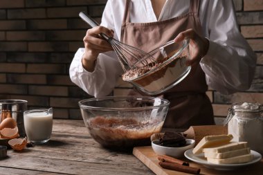 Mutfak masasında çikolata hamuru hazırlayan kadın, yakın plan.