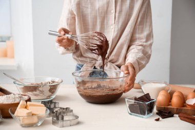 Mutfak masasında çikolata hamuru hazırlayan kadın, yakın plan.