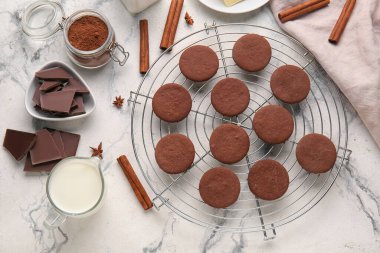 Lezzetli çikolatalı kurabiyeler ve beyaz mermer arka planda malzemelerle şebeke.