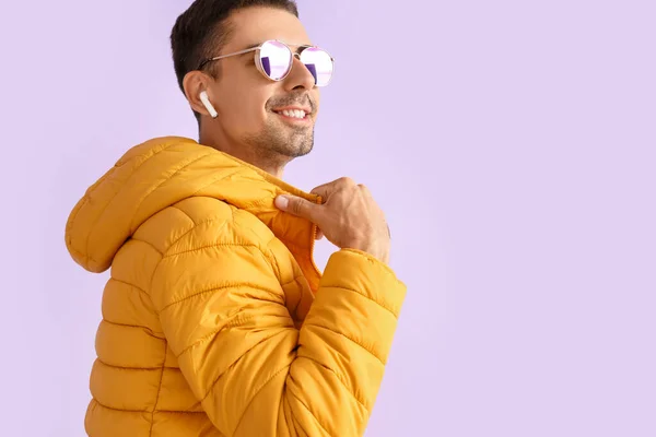 头戴太阳镜 身穿淡紫色背景黄色夹克的时髦年轻人 — 图库照片