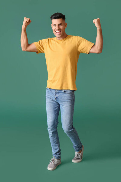 Счастливый молодой человек в стильной футболке на цветном фоне
