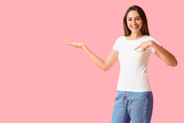 Jovem Mulher Branco Shirt Mostrando Algo Sobre Fundo Cor — Fotografia de Stock