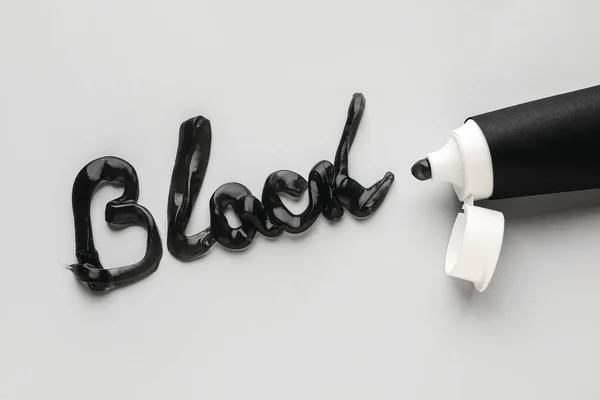 Word Black Made Black Tooth Paste Tube Light Background — Stock Photo, Image