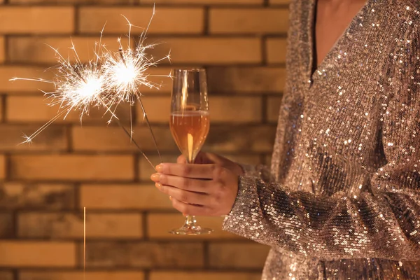 Donna Che Tiene Scintille Natale Bicchiere Champagne Sfondo Mattone Primo — Foto Stock