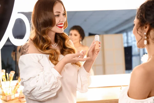 Makyaj sanatçısı güzellik salonunda güzel bir modelle çalışıyor.