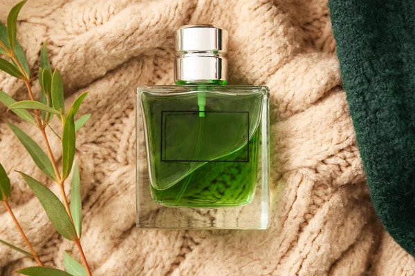针织物背景上的香水瓶和植物分枝 — 图库照片