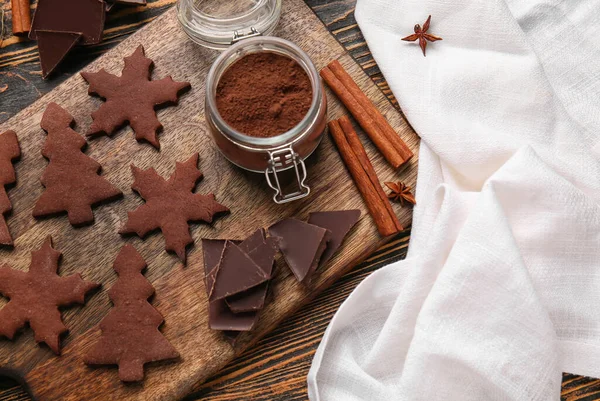 Ahşap arka planda lezzetli çikolatalı Noel kurabiyeleri olan tahta, yakın plan.