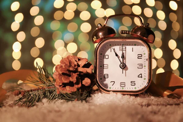スタイリッシュな新年の時計 背景をぼかしたテーブルの上のクリスマスの装飾と雪 — ストック写真