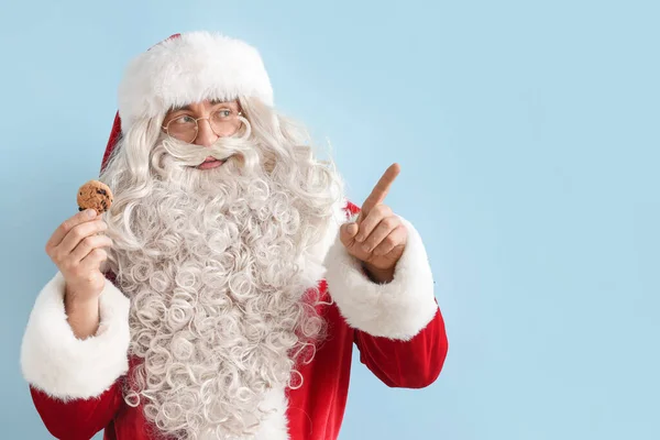 Санта Клаус Вкусным Печеньем Показывает Цветном Фоне — стоковое фото
