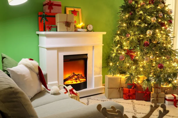 İçinde şömine, hediye kutuları ve büyük Noel ağacı olan oturma odası.