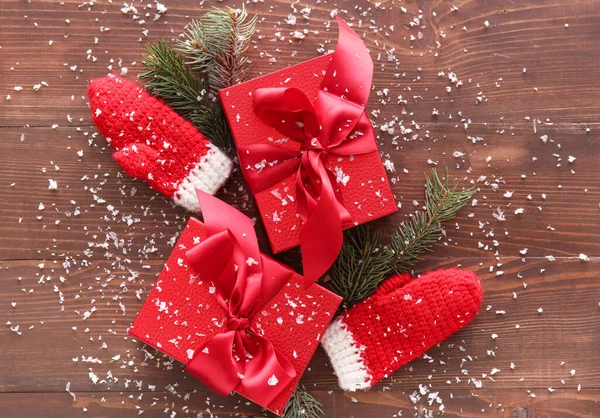 Красивая Композиция Рождественским Подарком Коробка Снег Варежки Деревянном Фоне — стоковое фото
