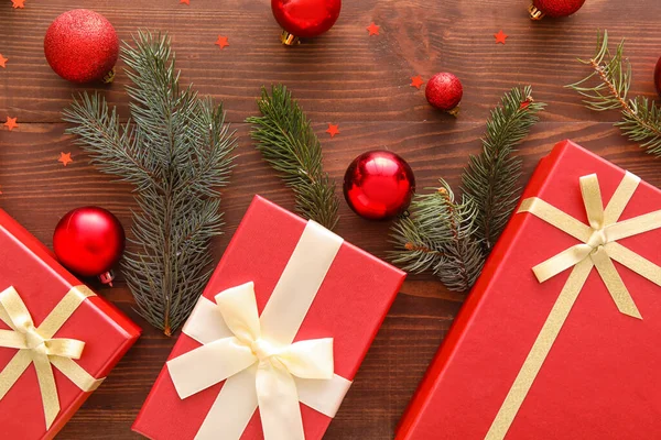 木製の背景にクリスマスギフトボックス モミの枝やボールと美しい組成物 — ストック写真