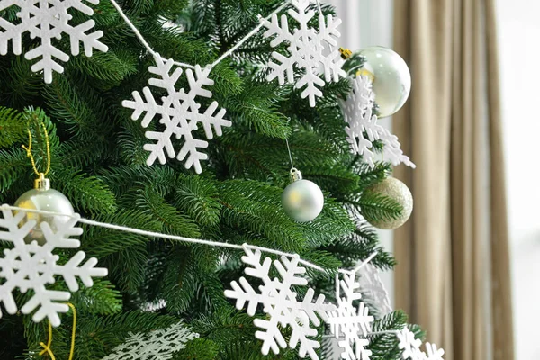 部屋に雪のフレークとボールで飾られた美しいクリスマスツリー クローズアップ — ストック写真