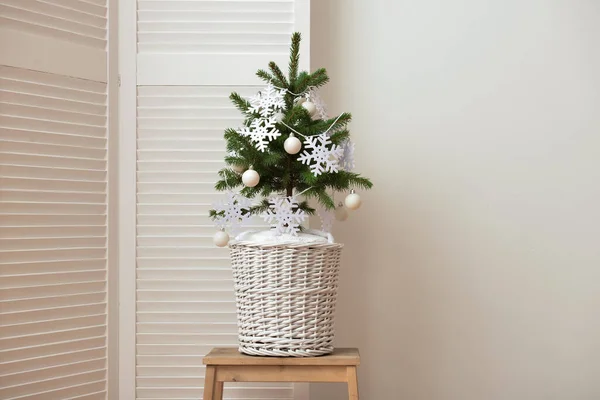 Gyönyörű Karácsonyfa Kosárban Díszített Hópelyhek Golyók Asztalon Közel Fény Fal — Stock Fotó