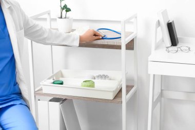 Kadın doktor klinikte steteskop kullanıyor.